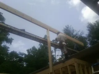 Carpenter setting a ridge beam over a new addition frame — Ice Dam Removal by Roofing Brothers in Wiota