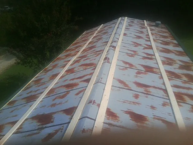 Rusted metal roof panels with new wood purlins before replacement — Storm Damage Roof Repair in Wiota by Roofing Brothers