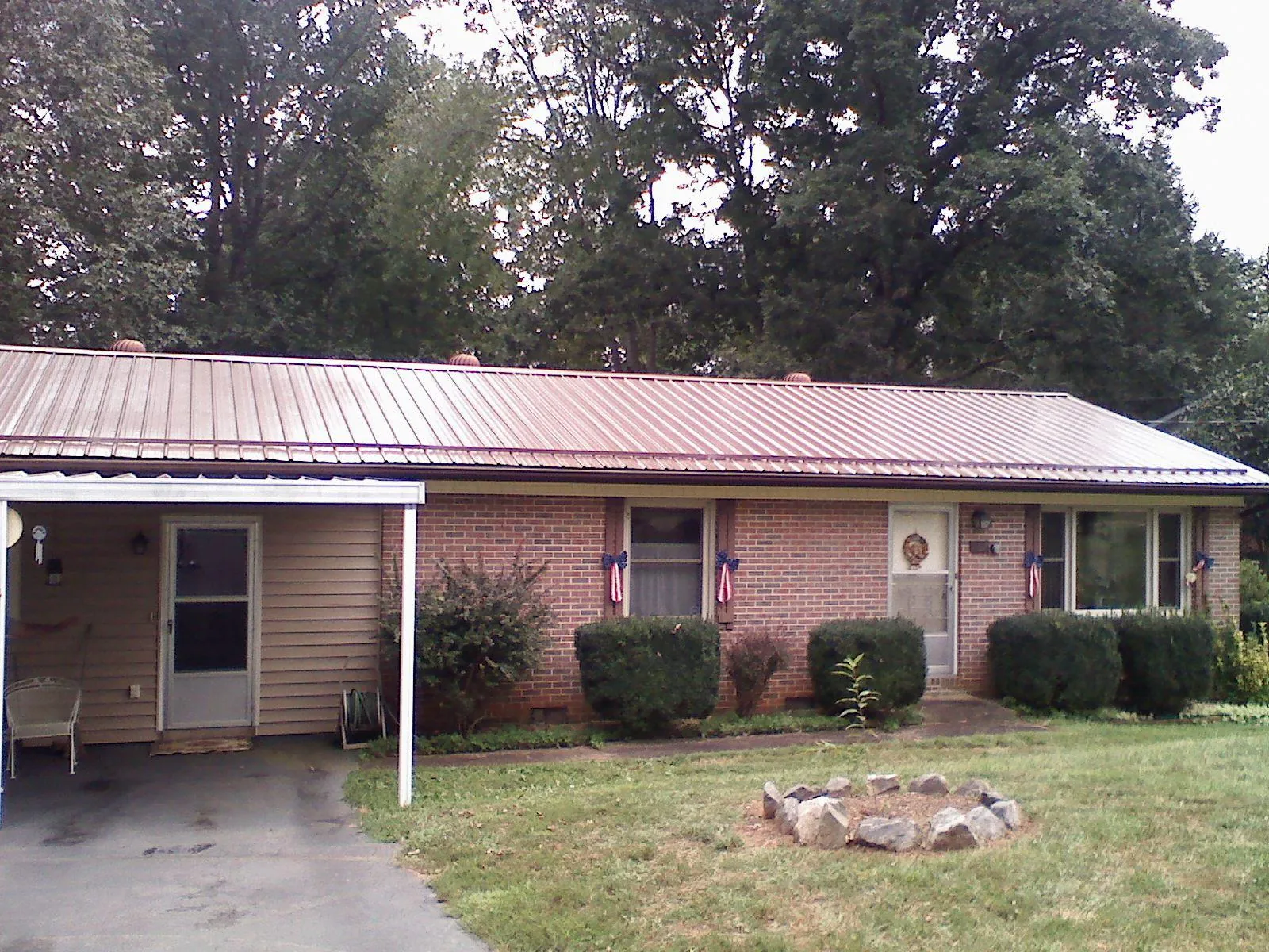 Bronze metal roof and carport on a brick ranch home — Roof Repair work by our crew in Wiota